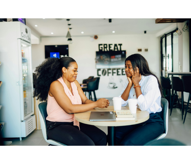 Two women socializing at a coffee shop