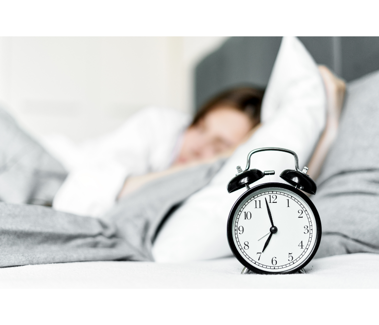 Person sleeping near an alarm clock