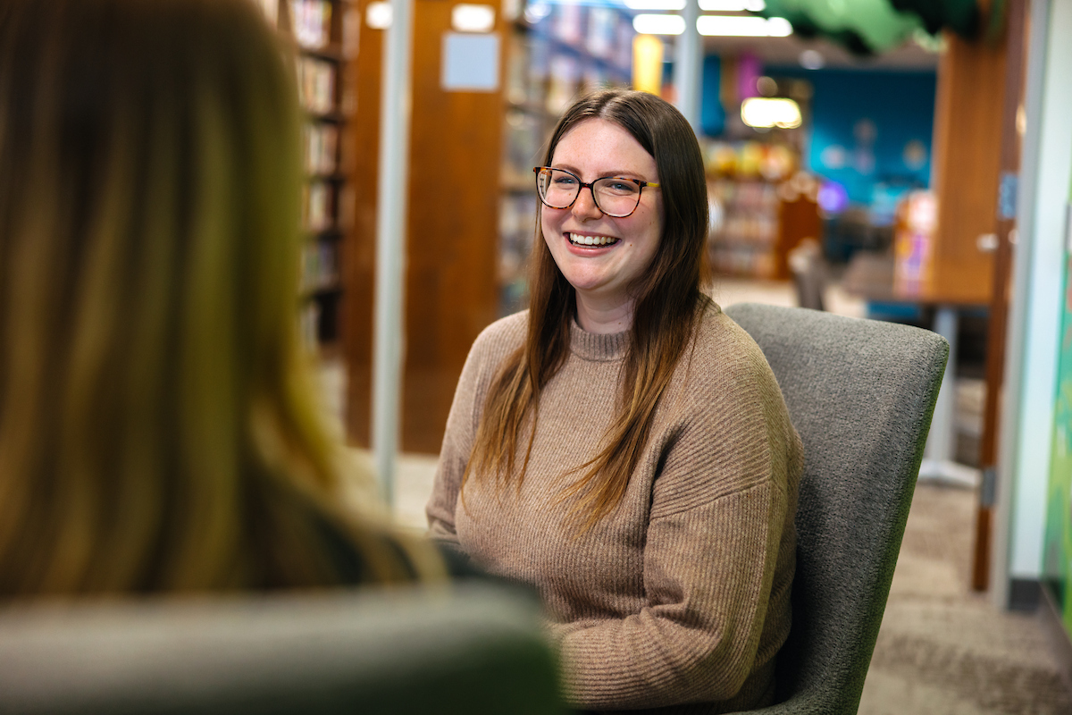 Woman in a conversation smiling.