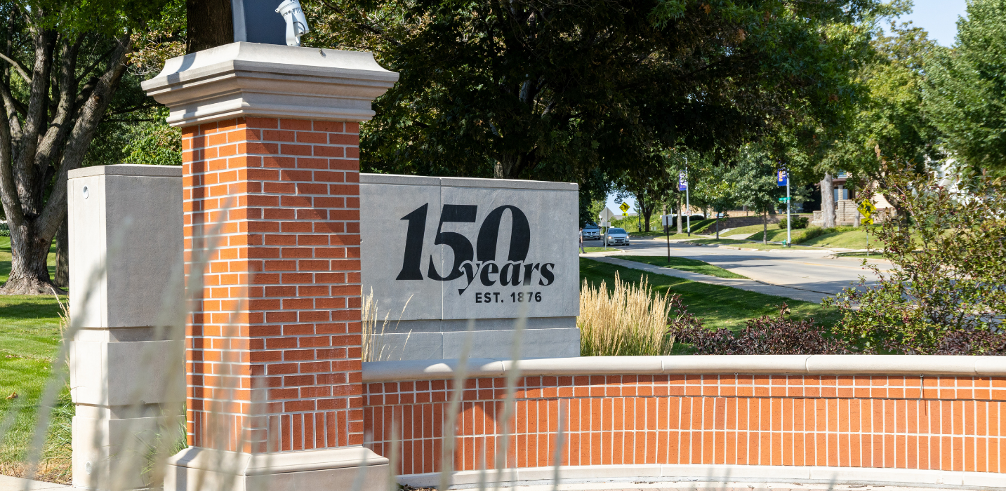 Campus entrance to the University of Northern Iowa with sesquicentennial logo.